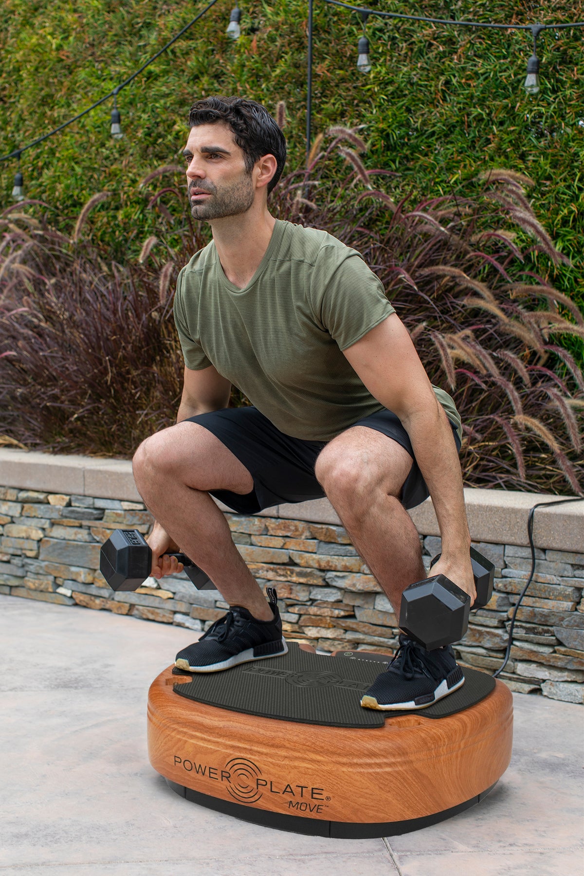 Man squatting on the Power Plate MOVE in Woodgrain outdoors